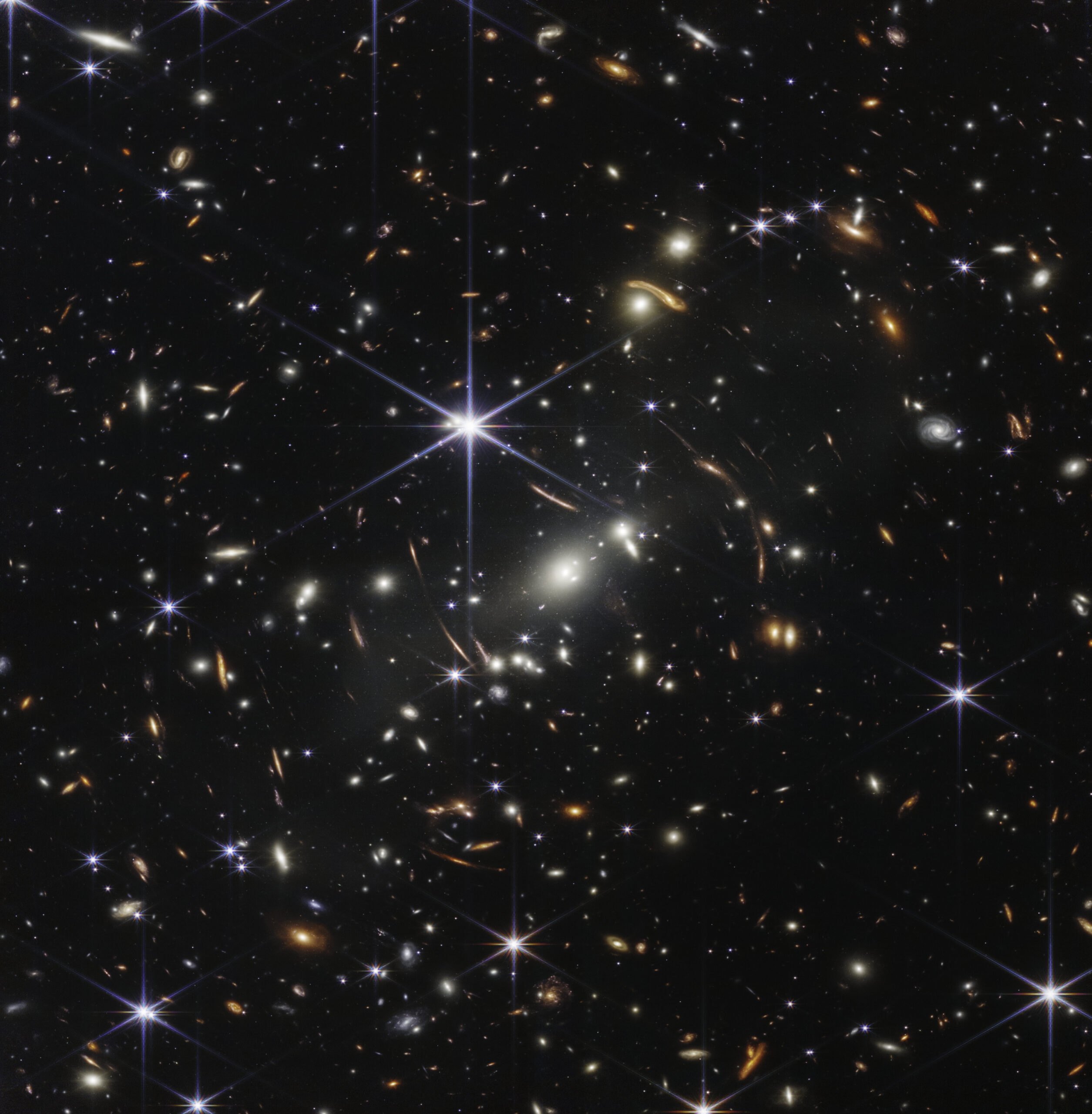 Jede noch so kleine Fleck ist eine Galaxie. Je röter desto weiter entfernt und desto älter. Auch die prominenten Graviationslinseneffekte sind beeindruckend sichtbar. Die erste veröffentlichte Aufnahme nach Betriebsbeginn des Teleskops, veröffentlicht am 11. Juli 2022. © NASA