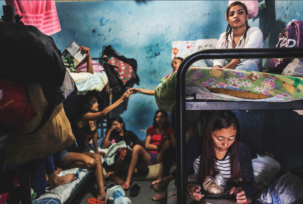 La Yaguara Haftzentrum, Caracas – März, 2018. Die Frauen in dieser Sicherungsverwahrungsanstalt verbringen ihren Tag in beunruhigender Untätigkeit. Sie gestalten ihre enge Zelle um und bemühen sich, so etwas wie ein Zuhause zu schaffen. Die Aktivitäten reichen vom Schreiben von Briefen oder dem Zeichnen für ihre Kinder über die Lektüre der Bibel bis hin zum Teilen von Zigaretten oder dem Glätten ihrer Haare. Ungleichheit verringern