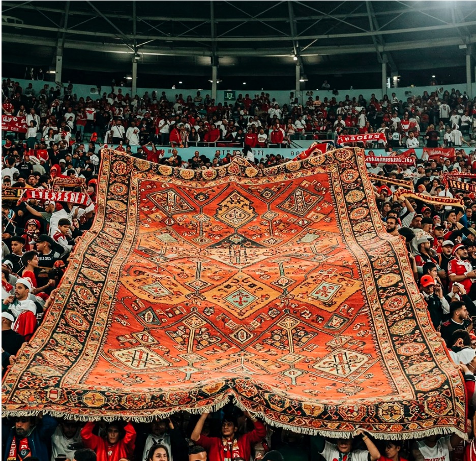 ULTRA
Ein Stadion-Publikum spannt einen Orientteppich als Fan-Choreo. Eine Geste zwischen Begeisterung und kultureller Aneignung.